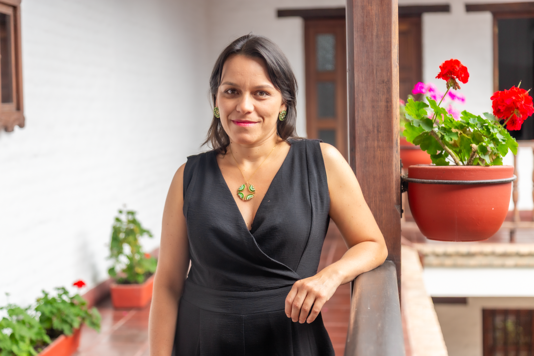 Ph.D. Ángela María Rodríguez Vivas, posando en una baranda de madera de la sede Academia-Empresa Unicomfacauca.