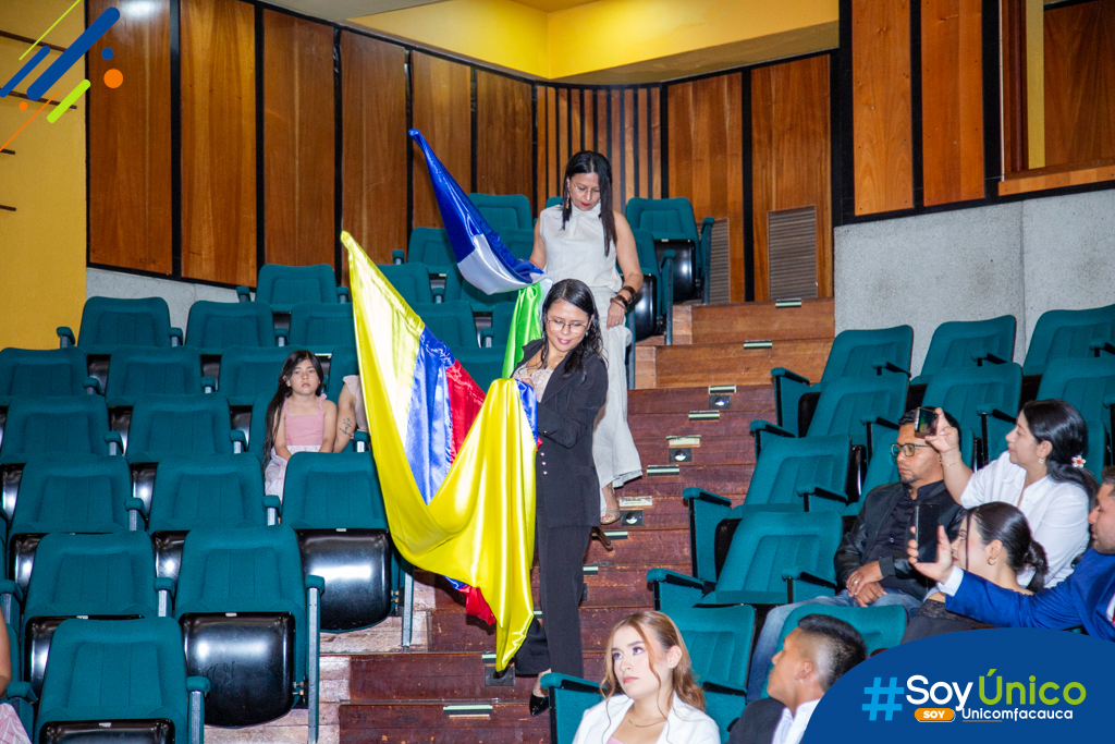 Ladys Margarita Correa Vivero y Ana María Torres Cifuentes realizando la entrega de la bandera Nacional e Institucional.