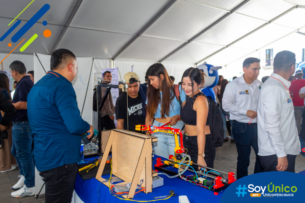 Estudiante unicomfacaucano presentando la Grúa a escala automatizada para cargas leves.