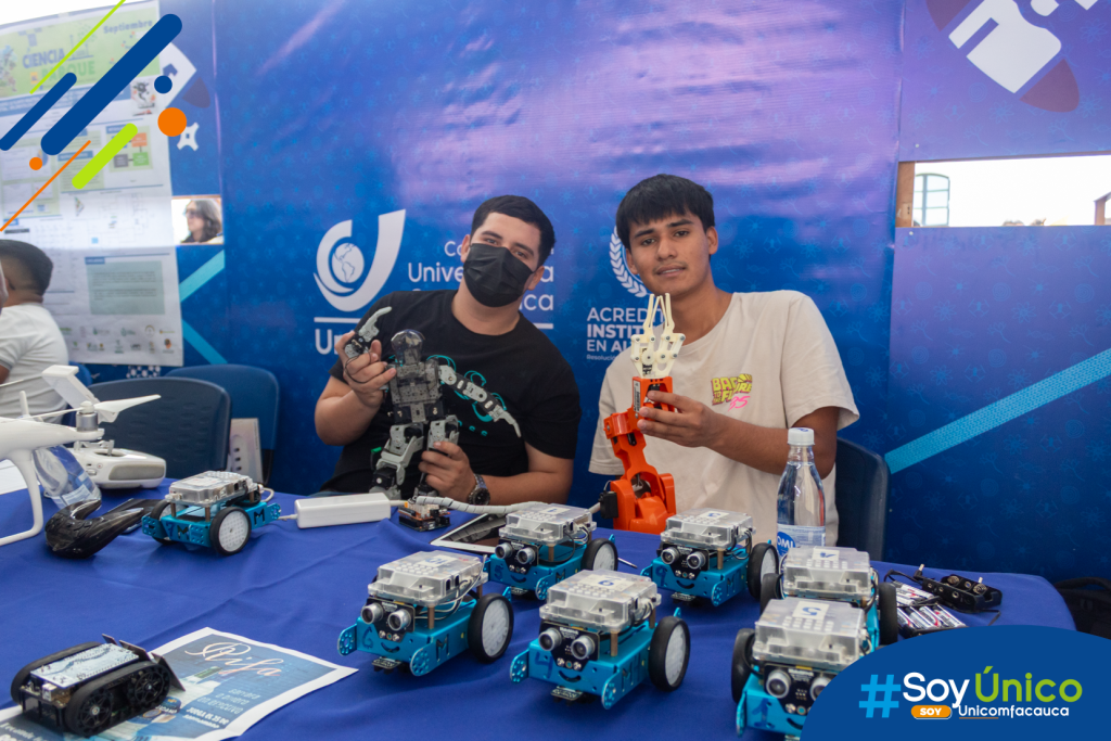 Estudiantes de nuestra Ingeniería Mecatrónica y miembros de nuestro Club de Robótica, posando con embots, brazo mecánico y un robor humanoide.