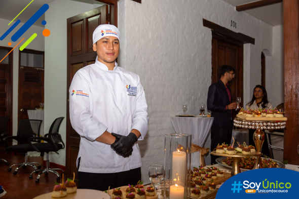 Estudiante de la Tecnología en Gestión Gastronómica atendiendo una de las mesas de pasabocas.
