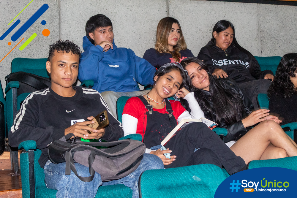 Estudiantes de Trabajo Social sonriendo y atendiendo el conversatorio.
