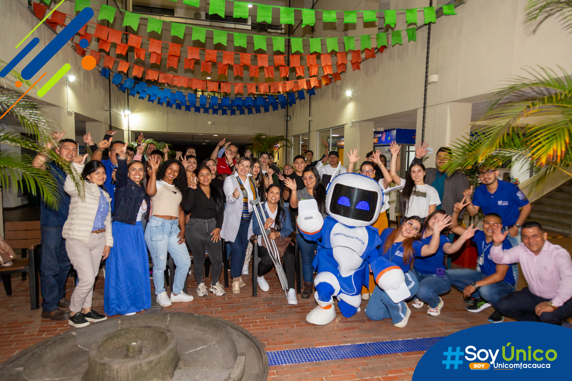 Fotografía grupal y alegre de nuestra Rectora, Mg. Claudia Milena García Castillo, junto con la Vicerrectora de Investigación y Extensión, Mg. Andrea Navas Calixto, junto con los estudiantes de "En Modo U" jornada nocturna, equipo de Mercadeo, Bienestar y nuestra mascota TUni.