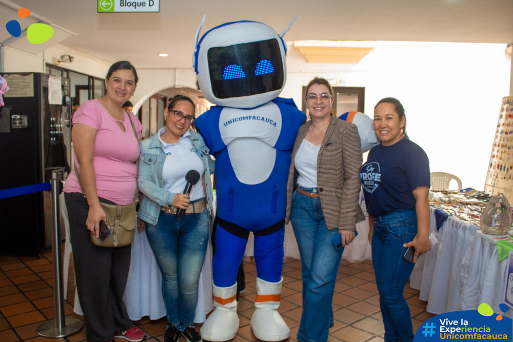 Vicerrectora de Investigación y Extensión, Mg. Victoria Eugenia Patiño Arenas; Coordinadora de la Unidad de Emprendimiento, Magaly Cerón y la docente Mabel Irene Paz, sonriendo al lado de la mascota institucional, TUni.