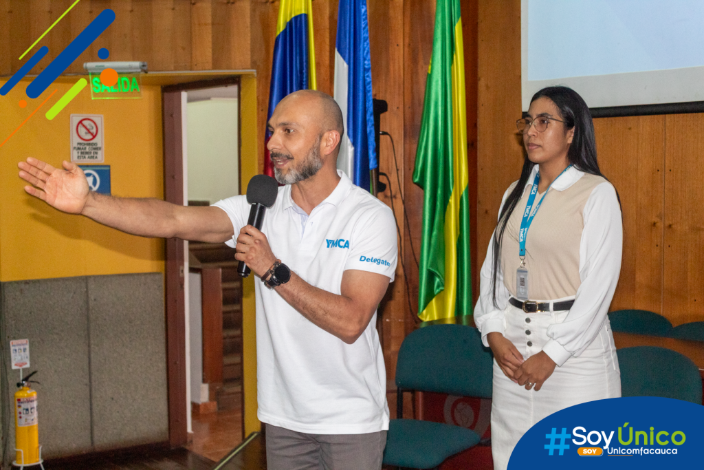 Jonh Jairo Dueñas Muñoz, embajador de YMCA, dirigiéndose hacia el auditorio en medio de su presentación.