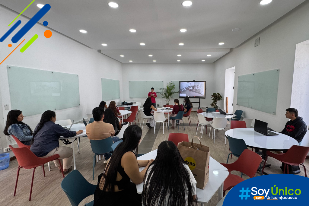 Fotografía en plano gran angular del Laboratorio de Innovación donde enseña a todos los presentes atendiendo uno de los pitch de los emprendedores.