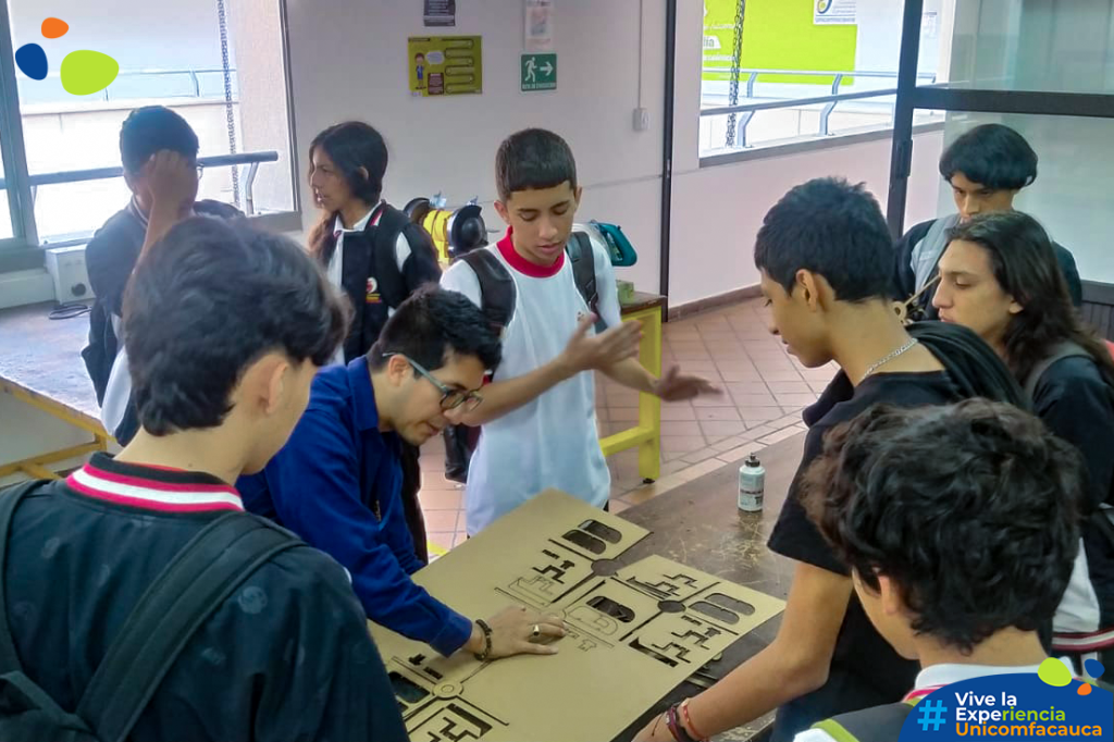 Estudiantes de 10º y 11º en el Laboratorio de Electromecánica mientras el director del programa de Ingeniería Mecatrónica, Mg. Saúl Eduardo Ruiz, los capacita en programación de robots y diseños mecatrónicos