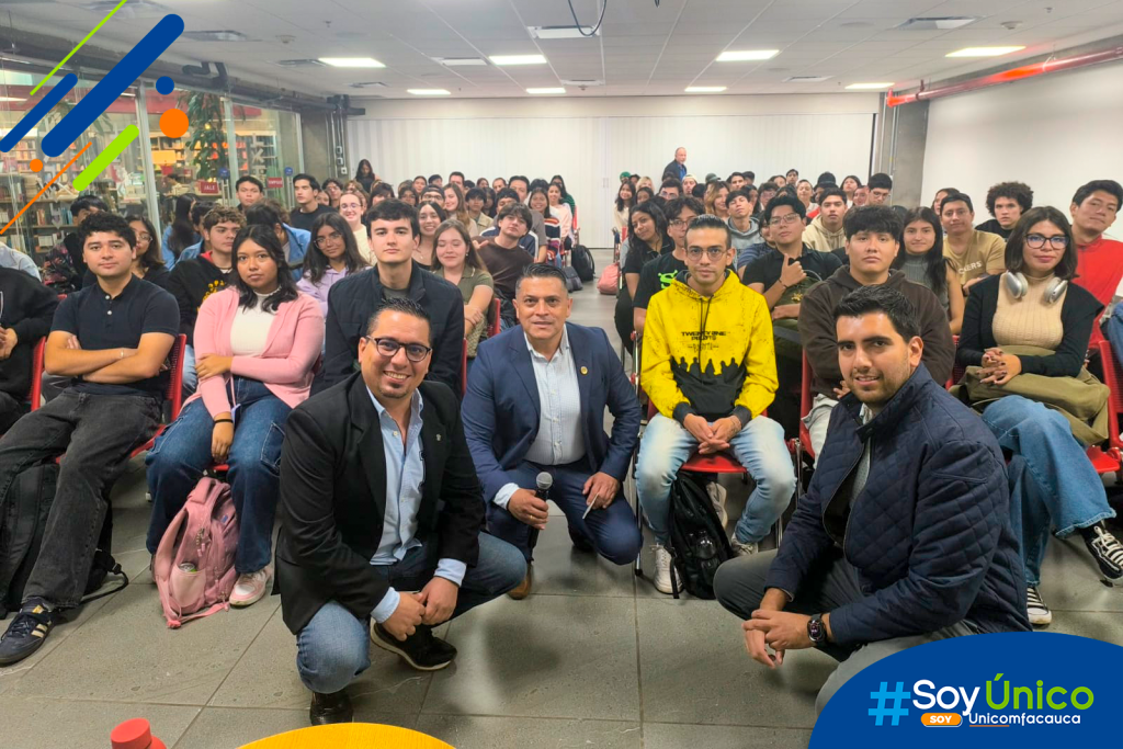 Fotografía grupal del Mg. Denis Augusto Lara Papamija, en compañía de otros académicos y un auditorio lleno de estudiantes.