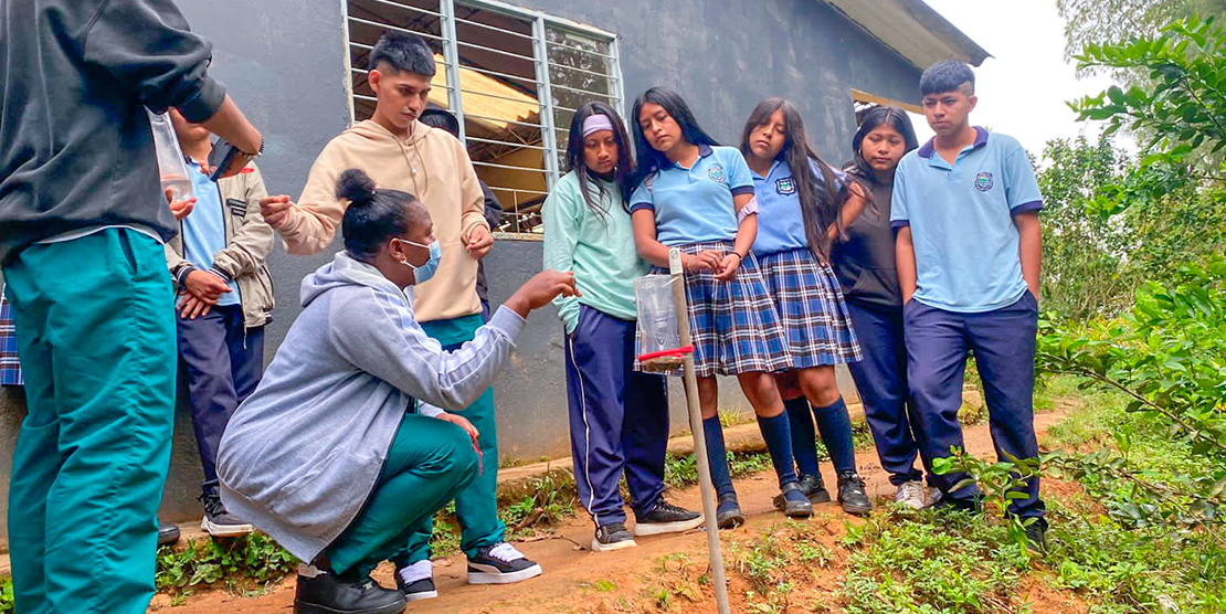 Estudiantes de tercer semestre de Ingeniería Agroambiental explicando el uso del pluviómetro.