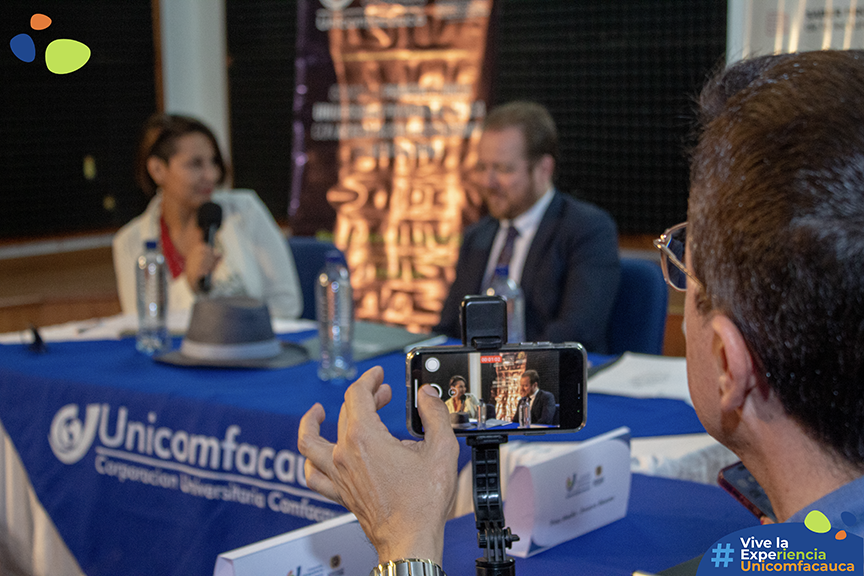Plano detalle de uno de los celulares de los periodistas grabando a la directora del programa de Comunicación Social y Periodismo junto con Juan Esteban Constaín.